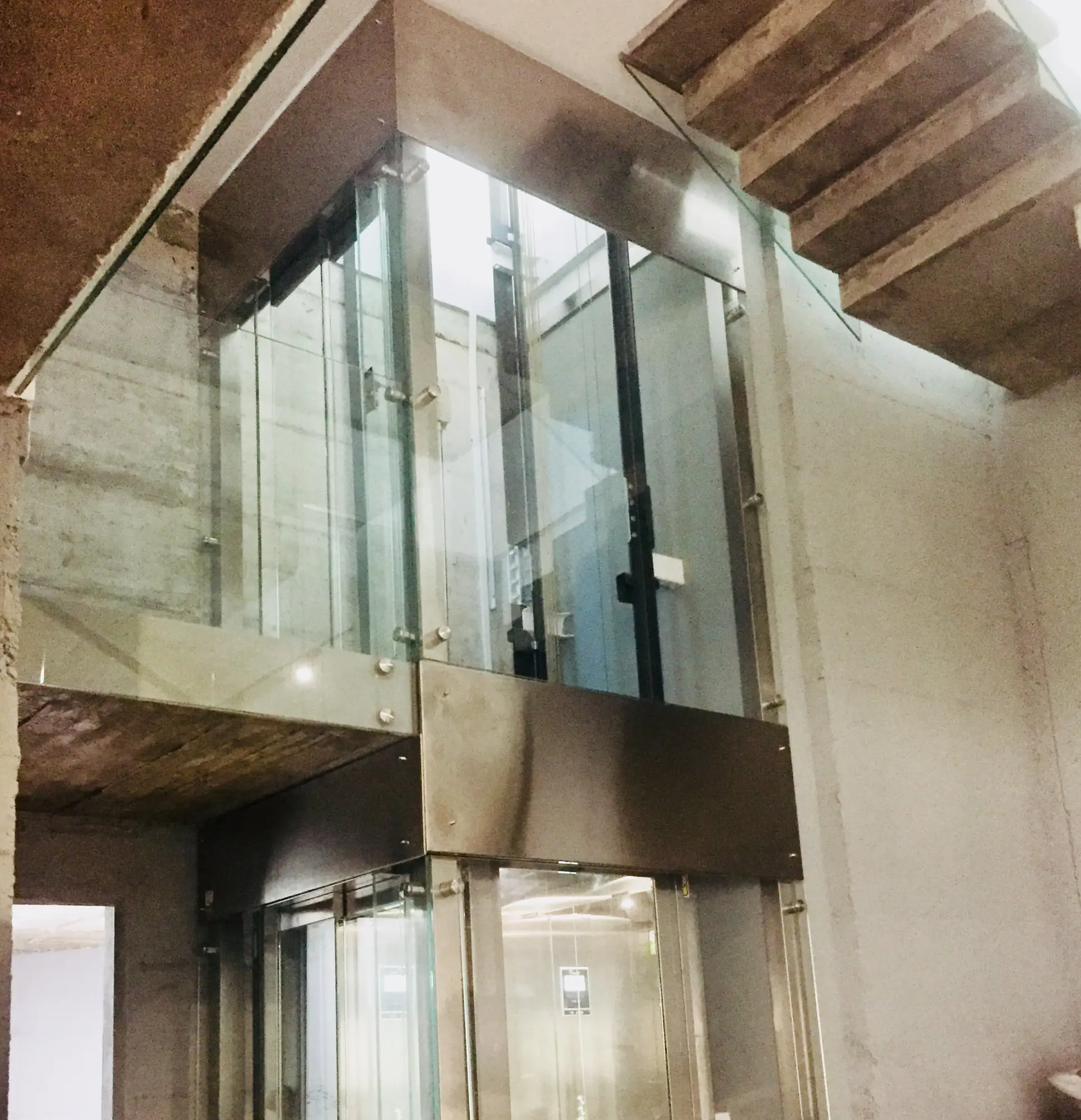 Ascensor panorámico de cristal en espacio a doble altura de Villa Alba, Nueva Andalucía, Marbella