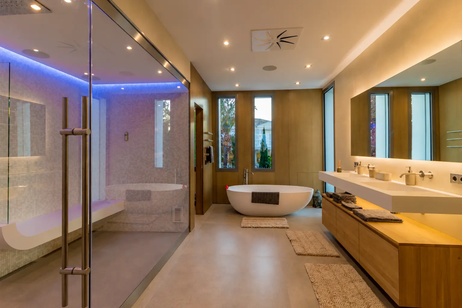 Baño principal con bañera exenta, mampara de cristal y madera en Villa Alba, Marbella