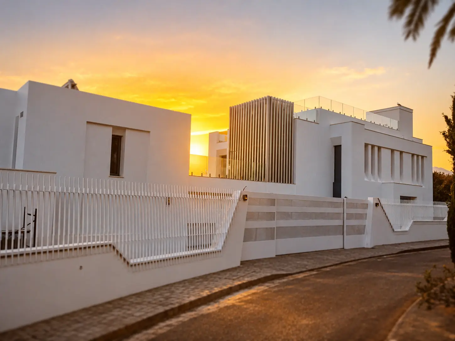 Fachada blanca de arquitectura contemporánea de Villa Alba al atardecer en La Pera, Marbella