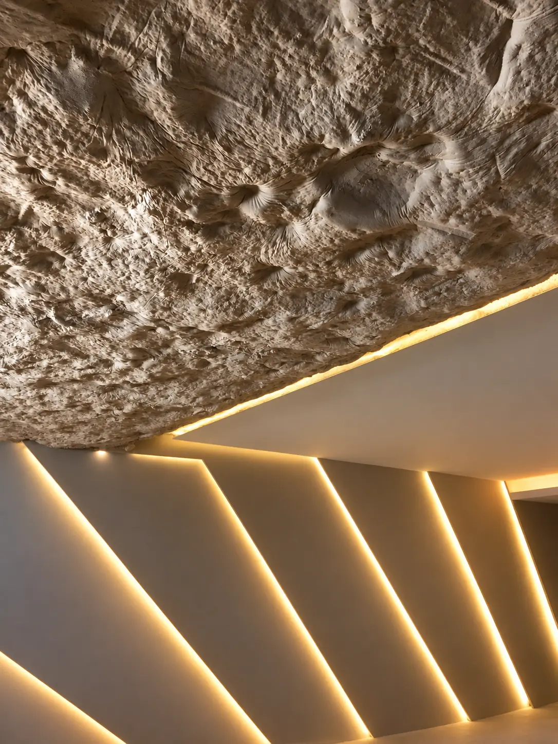 Detalle del techo de roca natural e iluminación lineal del gimnasio de Villa Alba, Marbella