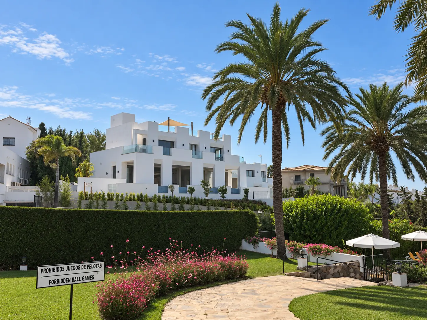 Jardín mediterráneo con palmeras y césped en Villa Alba, Nueva Andalucía, Marbella