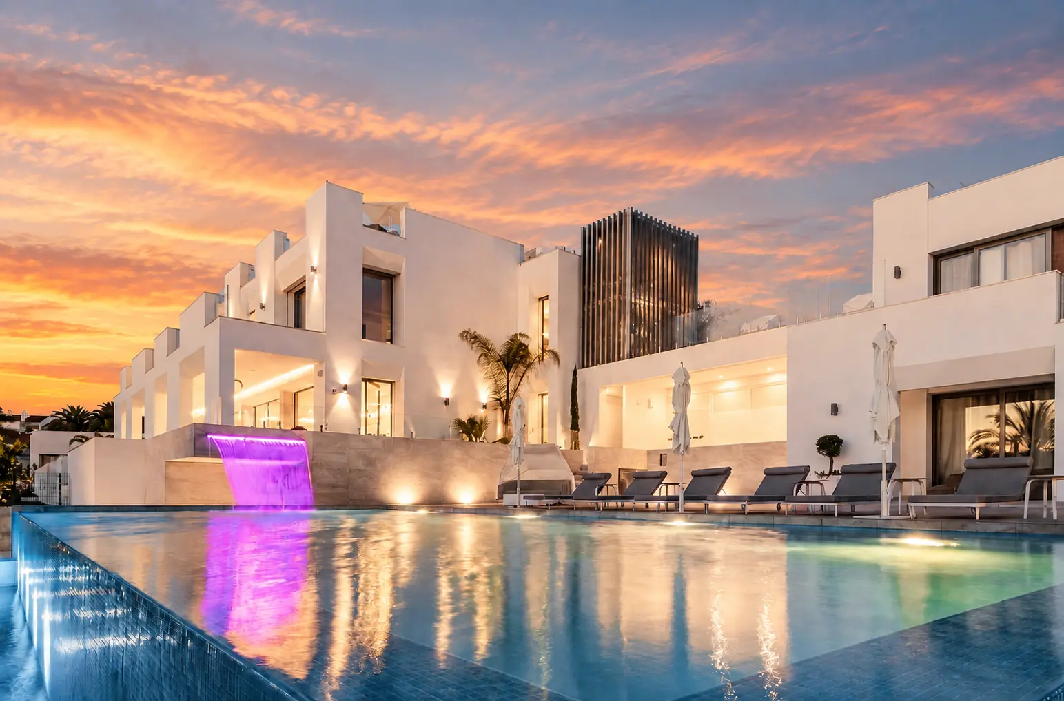 Piscina de recreo con cascada iluminada por la noche en Villa Alba, La Pera, Marbella